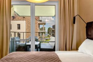 a bedroom with a bed and a view of a balcony at Nautica Resort in Giżycko +218 photos