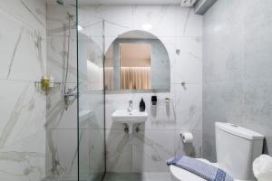 a white bathroom with a sink and a toilet at A&B Rooms Rodos Center in Rhodes Town