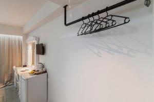 a room with a white wall with a light fixture on the wall at A&B Rooms Rodos Center in Rhodes Town