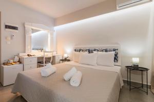 a white bedroom with a large bed with two white pillows at A&B Rooms Rodos Center in Rhodes Town