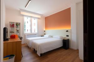 a bedroom with a white bed and a window at Bed & Bricks in Reggio Emilia