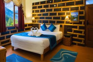 a bedroom with a bed with two swans on it at Manu Villa Manali - A Beautiful Cottage towards Snow Capped Mountain in Manāli