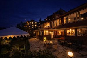 a building with a tent in front of it at night at Manu Villa Manali - A Beautiful Cottage towards Snow Capped Mountain in Manāli