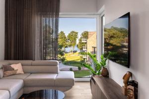 a living room with a couch and a large window at Nautica Resort in Giżycko