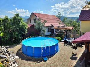 a large plunge pool in a yard next to a house at U Nazara in Slavske