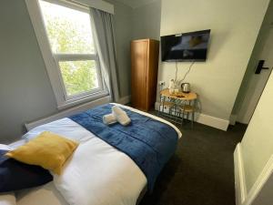 a bedroom with a bed with two pillows on it at The Kirkdale Hotel in Croydon