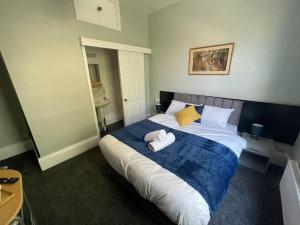 a bedroom with a large bed with two towels on it at The Kirkdale Hotel in Croydon