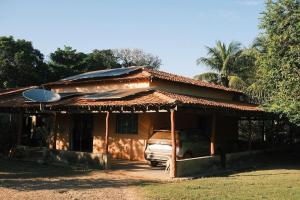 a house with a car parked in front of it at Casa em Sítio, 7km da Cidade in Poconé