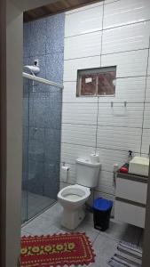 a bathroom with a toilet and a glass shower at Casa em Sítio, 7km da Cidade in Poconé