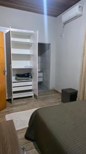 a bedroom with a bed and a room with a closet at Casa em Sítio, 7km da Cidade in Poconé