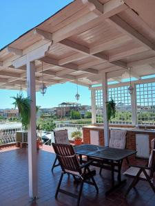 a wooden pergola with a table and chairs on a patio at Villa Mondi in Durrës