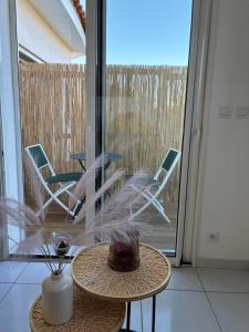 a room with a table and chairs and a window at Cocooning in Torreilles +15 photos