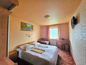a small bedroom with a bed and a television at U Nazara in Slavske