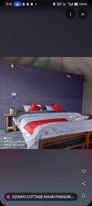 ein Schlafzimmer mit einem großen Bett und roten Kissen in der Unterkunft D cottage in Man