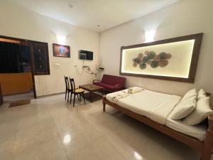a bedroom with a bed and a table and chairs at Villa Shakthi in Pondicherry