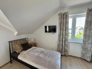 a bedroom with a bed and a window at Perła Chmielna in Chmielno
