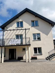 a large white building with a balcony at Perła Chmielna in Chmielno