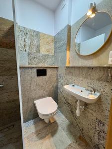 a bathroom with a toilet and a sink and a mirror at Perła Chmielna in Chmielno +10 photos