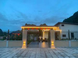 a gate to a house with lights on it at CoNa Homestay in Ðồng Khê Sâu