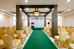 a room with rows of chairs and a green carpet at Hotel Aditya Grand in Guntūr