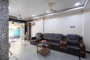 a living room with a couch and a table at Hotel Aditya Grand in Guntūr +16 photos