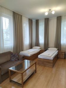 a living room with two beds and a coffee table at Klaipeda INN Private Parking and Kitchen in Klaipėda