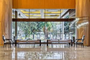 a lobby with tables and chairs and a large window at Divani Caravel in Athens
