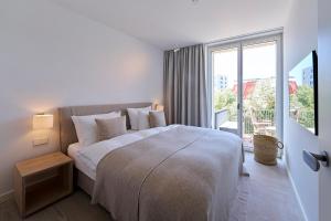 ein Schlafzimmer mit einem großen Bett und einem großen Fenster in der Unterkunft Inselhouse in Norderney