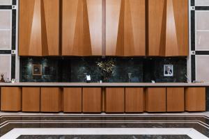 a lobby with a counter with wooden cabinets at Divani Caravel in Athens