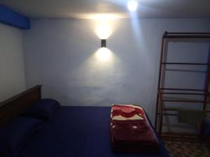 a room with a bed and a light on the wall at RK Guest in Nanu Oya
