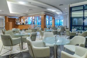 ein Restaurant mit Tischen und Stühlen in einem Raum in der Unterkunft Hotel Madeira Centro in Benidorm