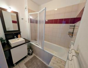 a bathroom with a shower and a sink and a tub at Cocon Luchon in Luchon +10 photos