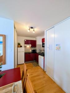 a kitchen with red cabinets and a white refrigerator at Cocon Luchon in Luchon