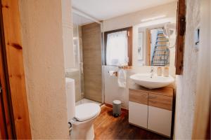 a bathroom with a white toilet and a sink at Casa Camino in Rubiana