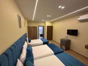a hotel room with two beds and a tv at Royal Night Pyramids View Inn in Cairo