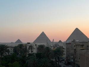 a view of the pyramids of giza at sunset at Royal Night Pyramids View Inn in Cairo