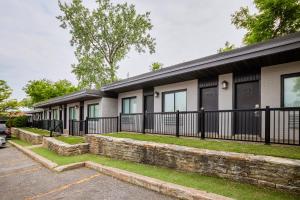 a building with a black fence and grass at Motel Newstar Laval in Laval