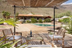 a patio with chairs and a swimming pool at Finca rural Los Tanquillos in San Bartolomé