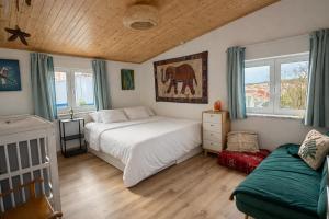 a bedroom with a bed and a couch and windows at CasaRica Retreat in Charneca +64 photos
