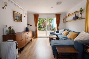 a living room with a blue couch and a window at CasaRica Retreat in Charneca