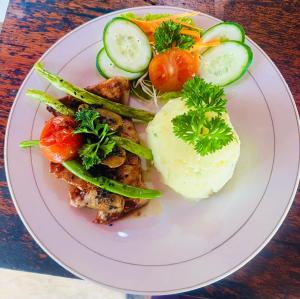 a plate of food with vegetables on a table at LAHANGAN SWEET cottages in Culik +21 photos