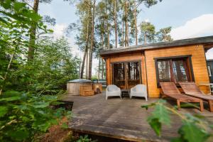 a tiny house with a deck and chairs at U Marcjana in Kamienica Królewska
