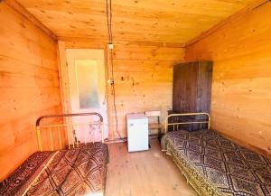 a room with two beds in a log cabin at David traditional Oda in Shuakhevi