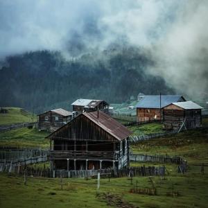 a group of old barns in a field at David traditional Oda in Shuakhevi