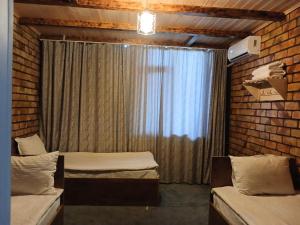 two beds in a room with a window at Мурас хостел in Var-Kyshtak