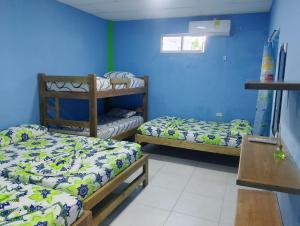 a room with two bunk beds and a blue wall at Villa faty in Coveñas