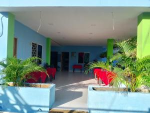 a hallway with red chairs and plants in a building at Villa faty in Coveñas