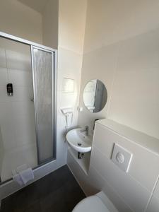 a bathroom with a toilet and a sink and a mirror at Potsdamer Inn in Berlin
