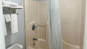 a bathroom with a shower and a toilet and towels at Studio 6 Suites Opelousas, LA in Opelousas +26 photos