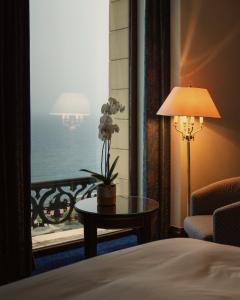 a hotel room with a bed and a table with a window at Rosewood Jeddah in Jeddah